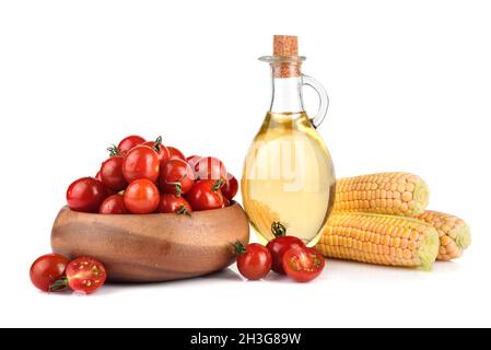 Ripe cherry tomatoes, corn in cobs and corn oil in glass bottle on white background Stock Photo