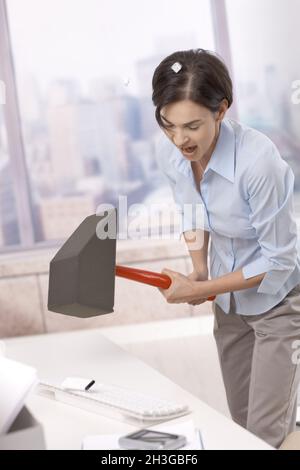 Frustrated office worker smashing keyboard Stock Photo