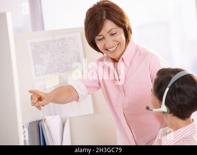 Senior supervisor helping customer care operator Stock Photo