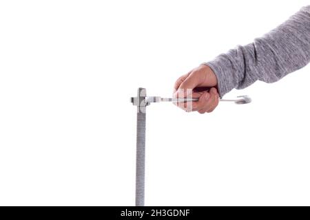 Man's hand tightening a nut with a wrench, isolated on white background. Stock Photo