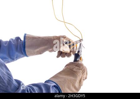 Gloved hands joining electric wires, isolated on white background. Protection and safety in electrician's work. Protected hands using two pliers to Stock Photo