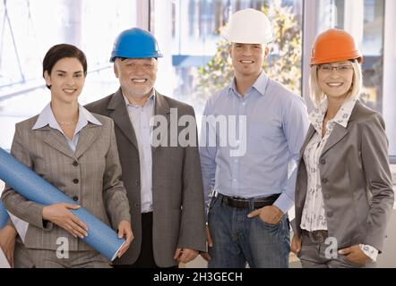 Smiling designer team wearing hardhat Stock Photo