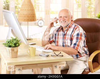 Happy old man on landline call Stock Photo