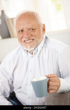 Smiling old man having coffee Stock Photo