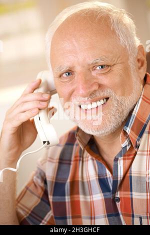 Older man on landline phone call Stock Photo