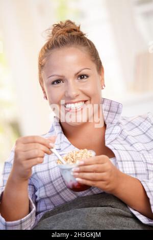 Young female having low fat breakfast in bed Stock Photo