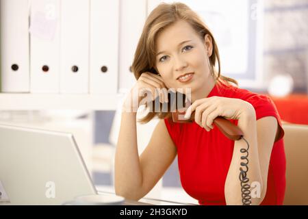 Office worker thinking with phone in hand Stock Photo
