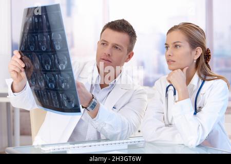 Two doctors studying x-ray image consulting Stock Photo