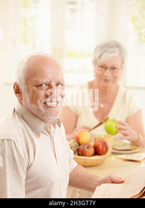 Portrait of older man at kitchen table Stock Photo