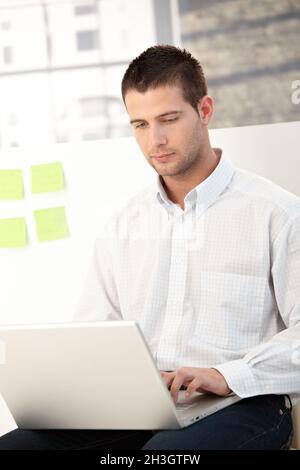 Casual office worker using laptop Stock Photo
