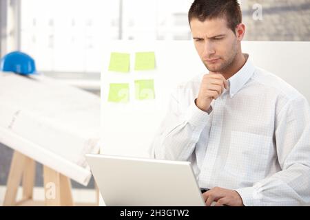 Young architect working on laptop Stock Photo