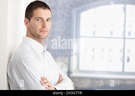 Handsome young man standing arms crossed Stock Photo