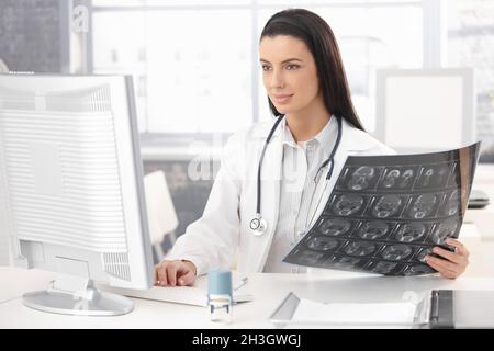 Smiling doctor working at desk Stock Photo
