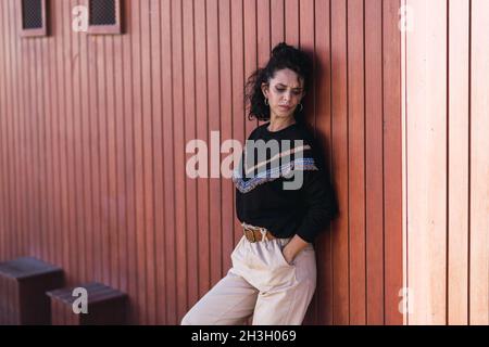 Spanish curly female posing near the wall Stock Photo