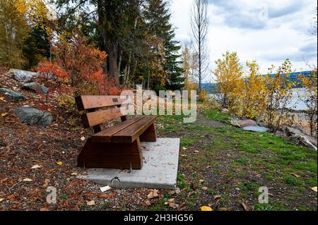 Photo of a wooden park bench facing towards Shuswap Lake in British Columbia Canada. Stock Photo