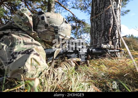 U.S. Army paratrooper assigned to the 173rd Airborne Brigade provides cover for his unit as a part of a simulated combat exercise during Bayonet Ready 22 at the Joint National Readiness Center in the Hohenfels Training Area, Germany, Oct. 21, 2021. Exercise Bayonet Ready 22 is a directive of the United States Army Southern European Task Force – Africa being conducted by the 7th Army Training Command and the 173rd Airborne Brigade at the Joint National Training Center in the Hohenfels Training Area, Germany from 17 to 30 Oct. 2021. The exercise is designed to facilitate the brigade commander’s Stock Photo
