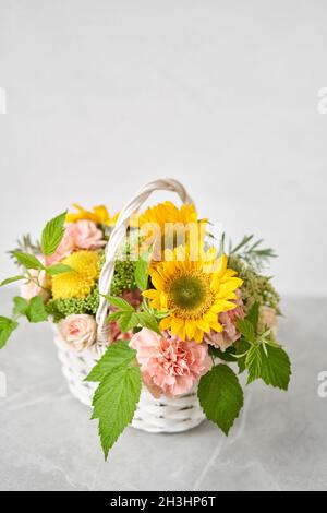 Flower arrangement in Wicker basket. Beautiful bouquet of mixed flowers. Handsome fresh bouquet. Small flower shop and Flowers delivery. Stock Photo