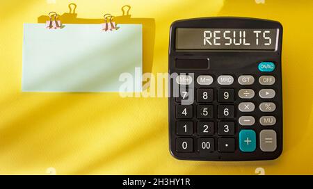 Success concept with the word Result on a calculator and yellow background. Next sticker to write Stock Photo