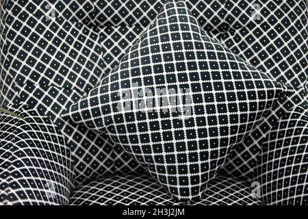 Geometric pattern with black and white rhombuses on the pillow and chair. Stock Photo