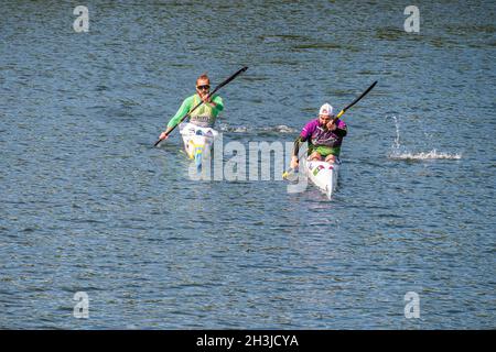 PLASENCIA, SPAIN - Apr 24, 2021: Two young men practicing canoeing riding in canoe navigating the Jerte river, Spain Stock Photo