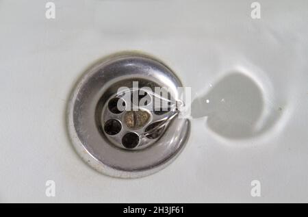 Water flowing away into a white stone sink Stock Photo