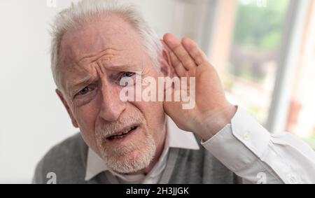 Portrait of senior man having hearing problems Stock Photo
