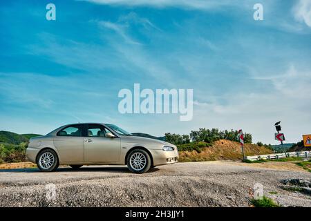 Beautifully designed Alfa Romeo 156  parking near the countryside gravel road Stock Photo