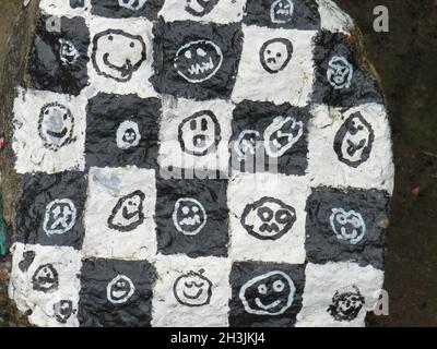 LANDSBERG AM LECH, GERMANY - Aug 29, 2021: A closeup shot of the black and white smiley faces painted on tree bark in  Landsberg am Lech, Germany Stock Photo