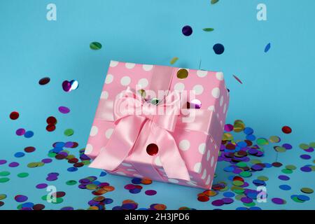 Pink gift box and glitter on blue background Stock Photo