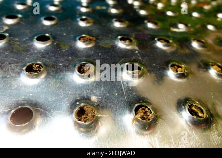 Shiny metal curved surface with holes. Background image Stock Photo