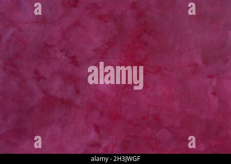 Painted,  layered surface of the wall in magenta and red  tones Stock Photo