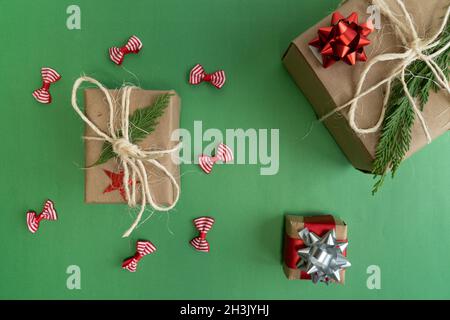 Three boxes christmas gift with red ribbon on green background, top view concept idea photo Stock Photo