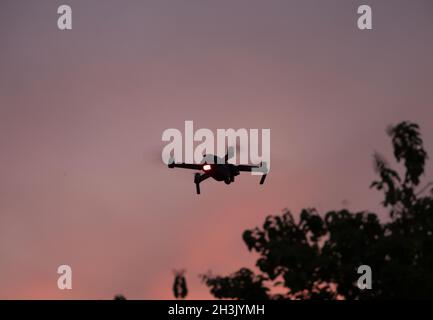 Drone flying against a sunset sky Stock Photo - Alamy