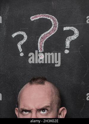 Confused man and question marks Stock Photo