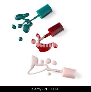 Bright colored nail polish bottles with drippings on white background Stock Photo