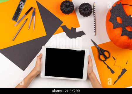 Preparing for Halloween. Teenage kid hands cutting black paper bat with  scissors and making Halloween party decorations on white table at home. Top  Stock Photo - Alamy