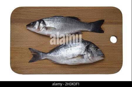Fresh raw sea bass and dorado fish on wooden cutting board, top view Stock Photo