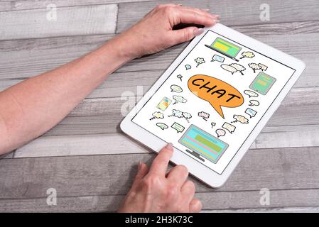 Chat concept shown on a tablet used by a woman Stock Photo