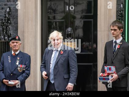 10 Downing Street, London, UK. 29th October 2021. Prime Minister Boris Johnson purchases a poppy at front of the Number 10 door from fundraisers for the Royal British Legion at the start of the Poppy Appeal launch. Credit: Malcolm Park/Alamy Live News. Stock Photo
