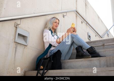 a professional young blonde woman using a smartphone. selfie Stock Photo