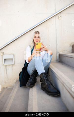 a student young blonde woman using a smartphone. selfie Stock Photo