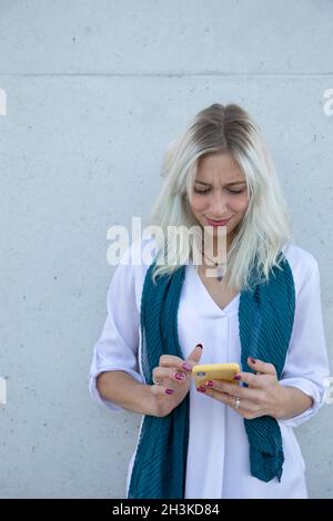 a professional young blonde woman using a smartphone. selfie Stock Photo