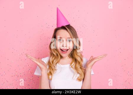 Photo portrait woman in white t-shirt pink cone smiling amazed excited at party isolated pastel pink color background Stock Photo