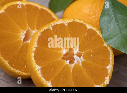 Fresh ripe tangerines with leaves on a wooden background. Close up view. Stock Photo