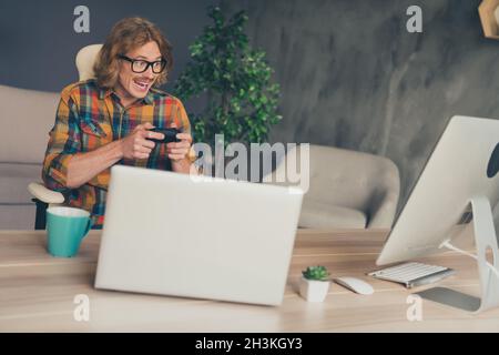 Photo portrait man in glasses playing video games on working break relaxing in office Stock Photo