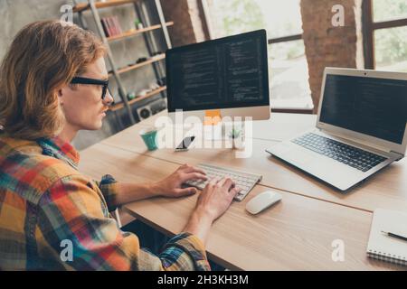 Profile side photo of young man typing keyboard coder programmer computer screen cyberspace virtual indoors Stock Photo