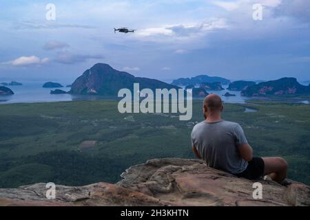Back view of man drone operator on the mountain view point Stock Photo