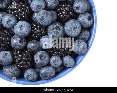Bowl full of fresh blackberries and blueberries on white background. Stock Photo