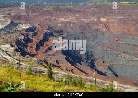 Large industrial quarry for the extraction of iron ore with working equipment, top view. 