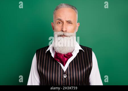 Photo of senior handsome british man think thoughtful wink eye well-dressed isolated over green color background Stock Photo